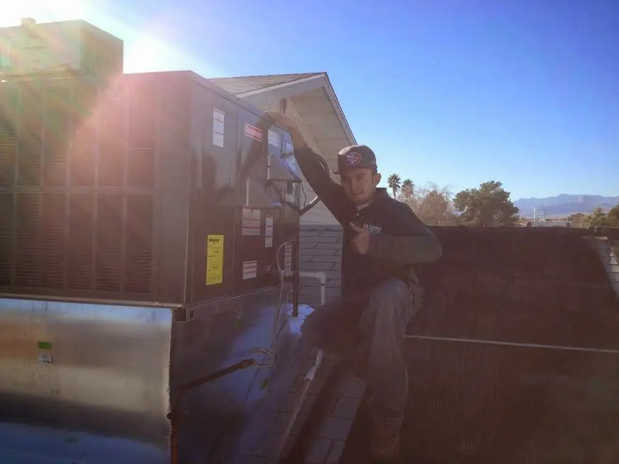 HVAC technician performing HVAC Inspection on a rooftop unit in Frankford